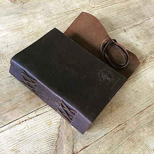 Distressed leather notebook, slightly open and placed on a wooden table