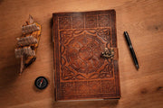 A4 tan leather journal on table next to pen, compass and model ship
