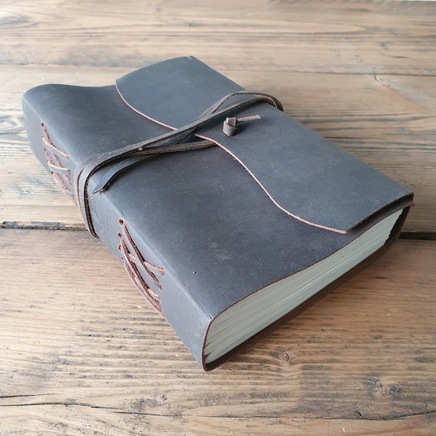 Vintage leather journal with wrap around tie, placed on a wooden table